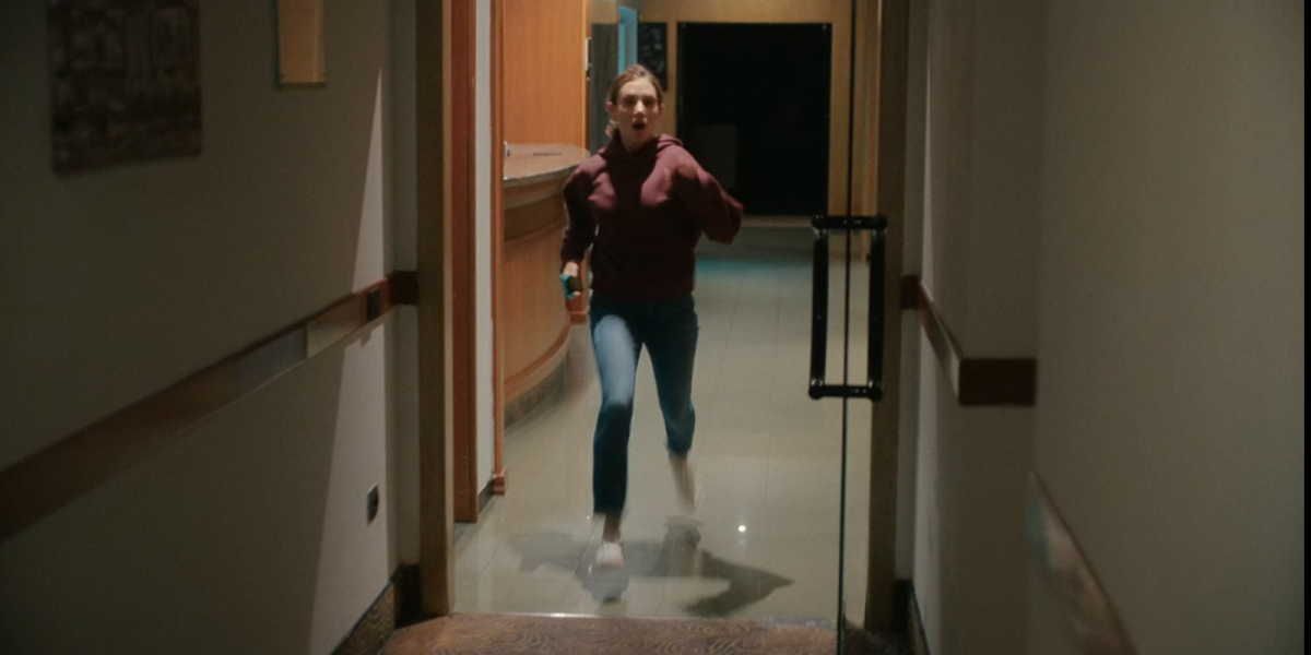 Alison Brie running in a burgundy hoodie, jeans, and white sneakers