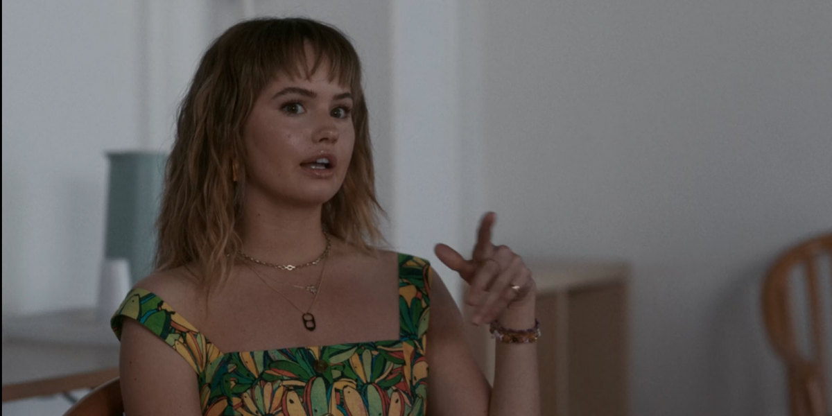 Debby Ryan talking wearing a necklace with a soda pop top