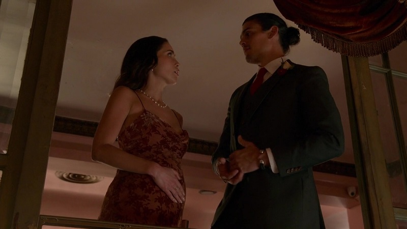 Isabella and Gael stare lovingly at each other after he announces their relationship to the entire reception. He's wearing a tux and she's wearing a dress, with her hand on top of her baby bump.