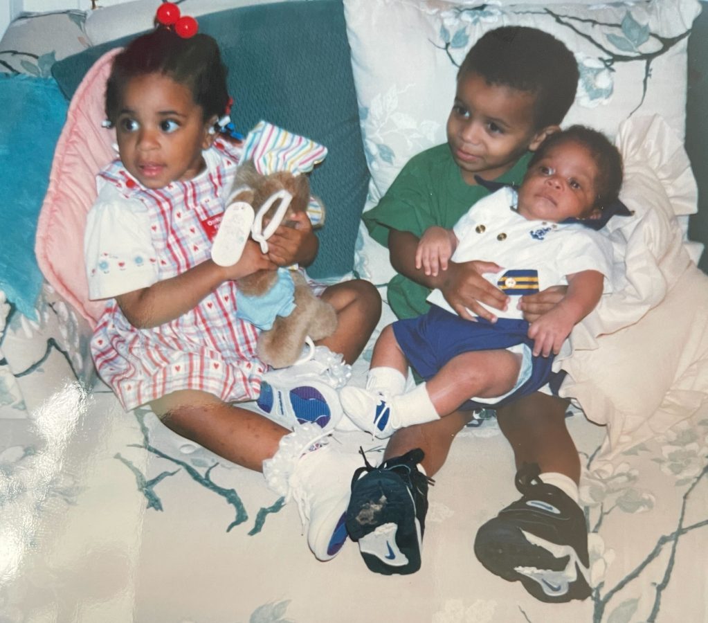 Dani, Dave, and Dakota sit on a couch, Dave is holding Dakota