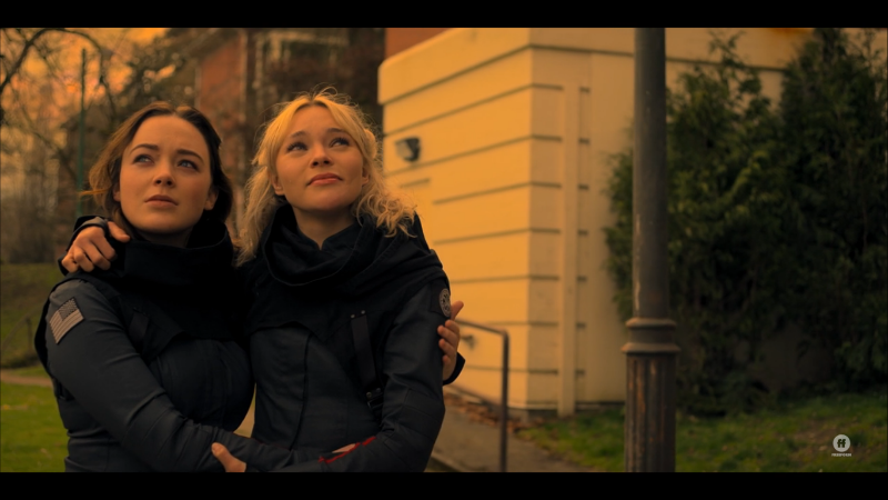 Scylla and Raelle hold each other as they look up to the new sky