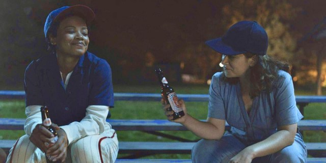 A League of their Own review: Chante Adams, playing Max, and Abbi Jacobson, playing Carson, share a beer by the baseball diamond under nightfall.