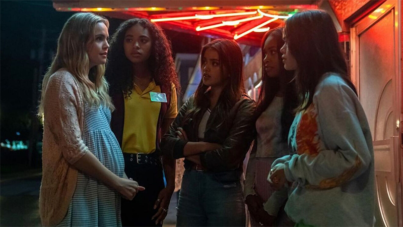 The new Little Liars huddle together in front of a neon light