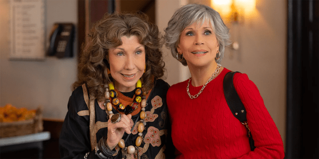 Lily Tomlin and Jane Fonda as Grace and Frankie, linking arms and smiling