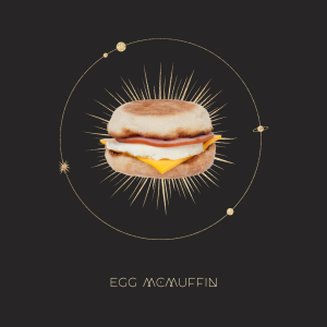 diagramă astrologică cu un cerc de stele, o imagine a unui Egg McMuffin în mijlocul unei explozii, cu text de mai jos pe care scrie Egg McMuffin