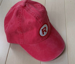 A vintage red baseball cap with an R on it