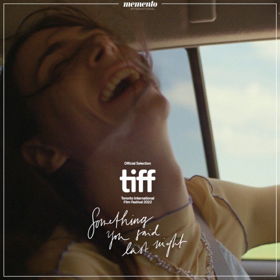 the cover of something you said last night shows a person laughing with a wide mouth, head thrown back, in the wind of an open car window