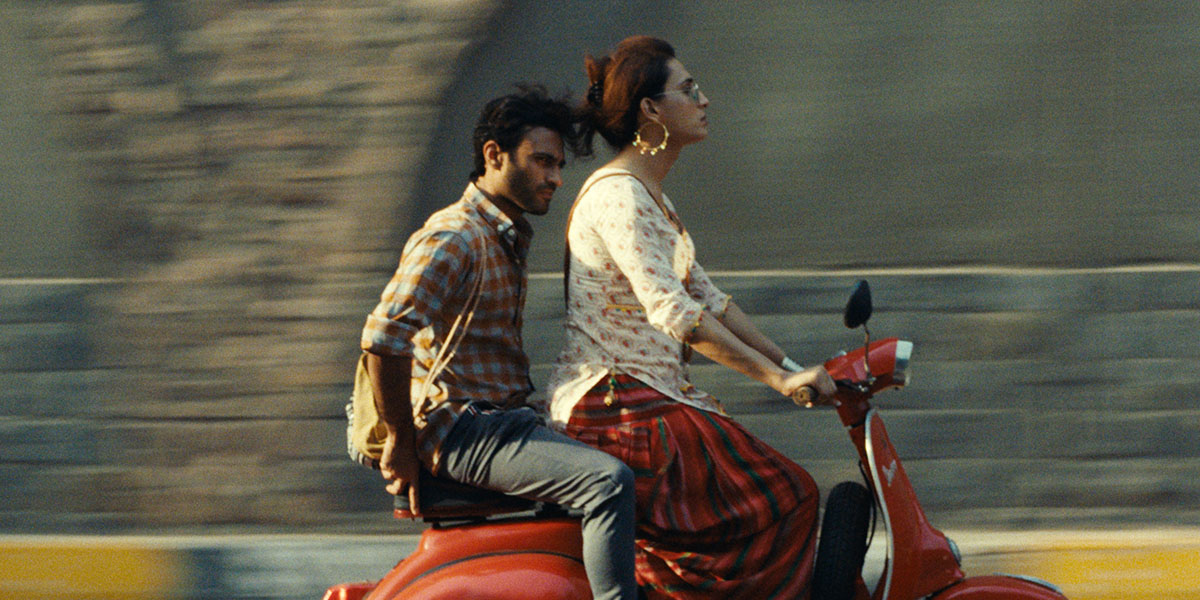 Ali Junejo as Haider rides on the back of a moped driven by Alina Khan as Biba.