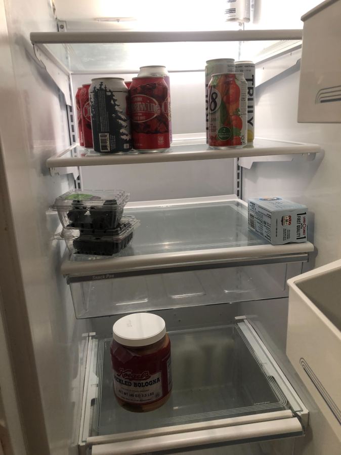 a single photo of kayla's mostly bare fridge with a beer, butter, a V8, cheerwine sodas, blueberries and yes, pickled bologna