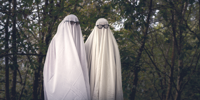 Two sheet ghosts in the woods wear sunglasses