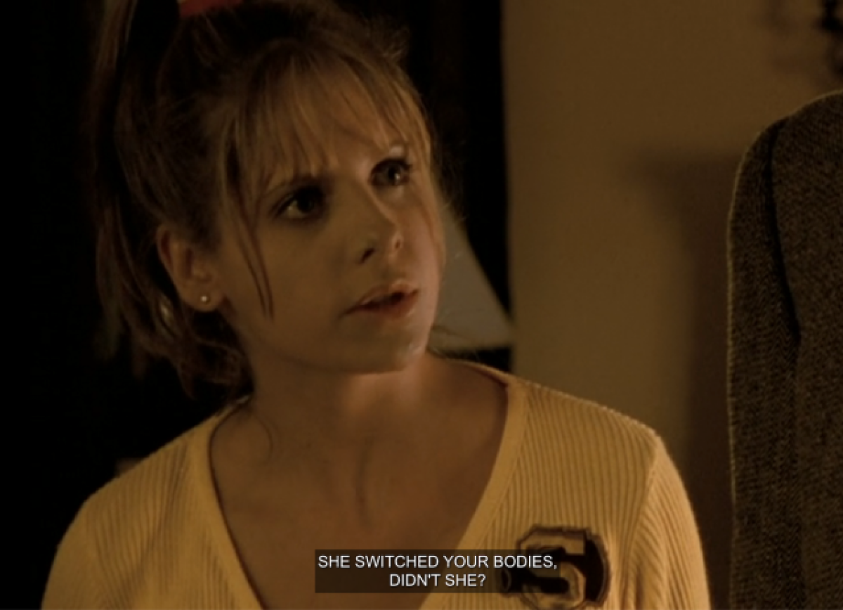 Buffy wearing a yellow cheerleading shirt. The closed captions show that she is saying “she switched your bodies, didn’t she?”