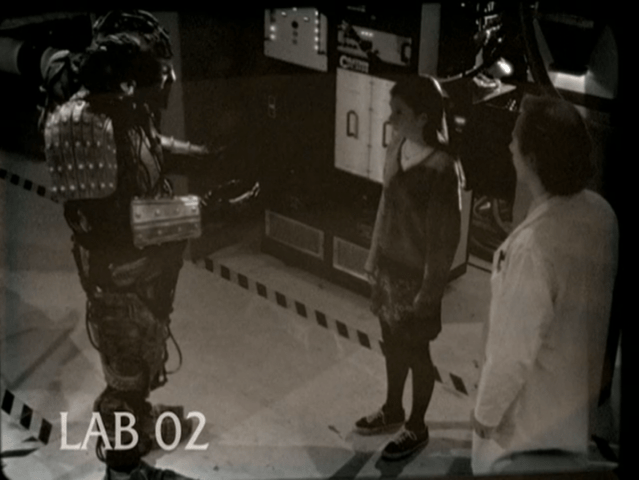 A security camera image that says LAB 02 and shows Willow, an engineer, and a demon inhabiting a robot body.
