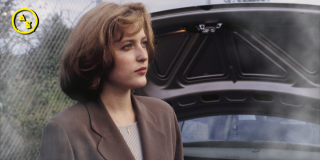 Dana Scully stands in front of an open car trunk