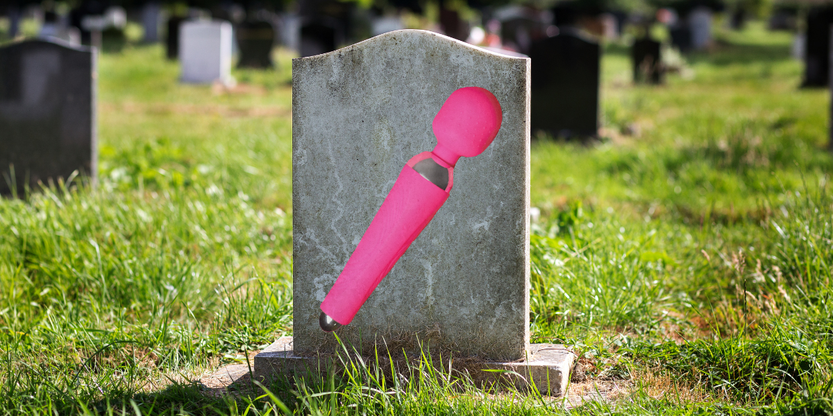 a tombstone in a graveyard featuring an image of a large pink vibrator on its stone
