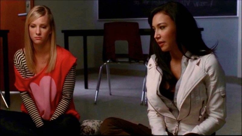 Santana sits next to her girlfriend Brittany on the floor of their high school classroom