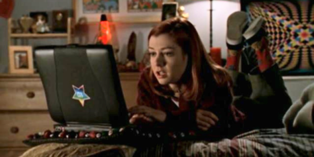 Willow Rosenberg sits on her bed looking at her computer