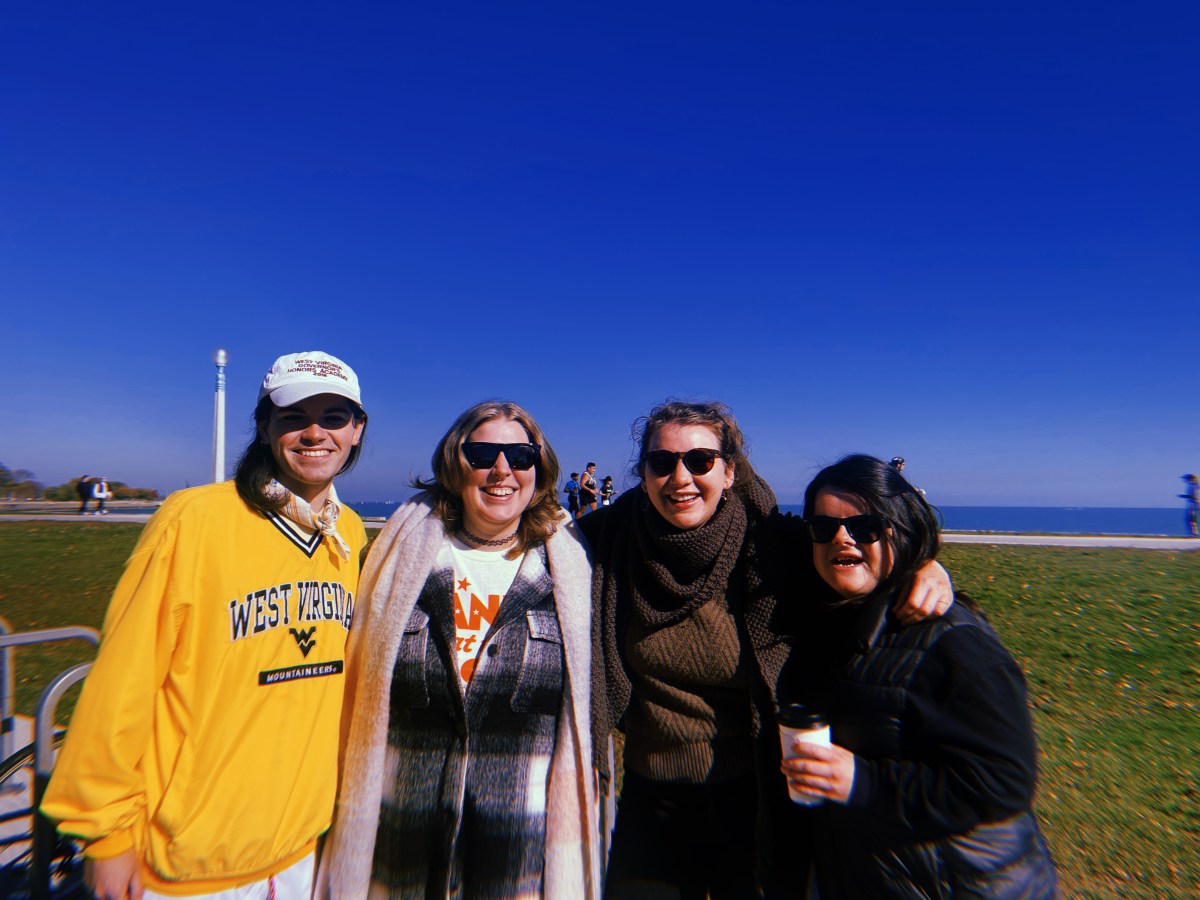 Four queer folks smiling on the Chicago lakefront.