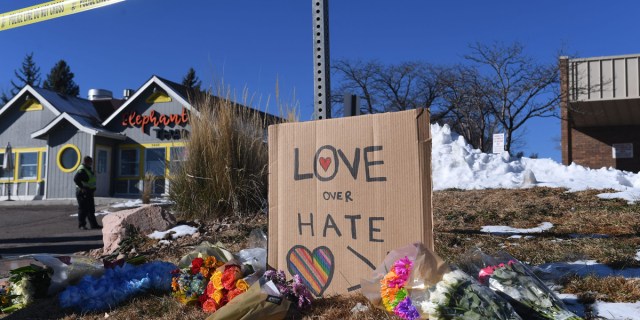 Bouquets of flowers and a sign reading "Love Over Hate" are left near Club Q, an LGBTQ nightclub in Colorado Springs, Colorado, on November 20, 2022. - At least five people were killed and 18 wounded in a mass shooting at an LGBTQ nightclub in the US city of Colorado Springs, police said on November 20, 2022.
