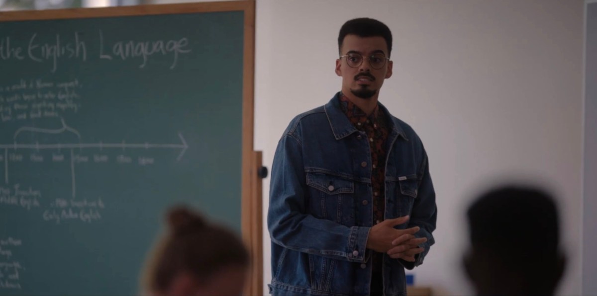 Teacher in a denim jacket at front of class