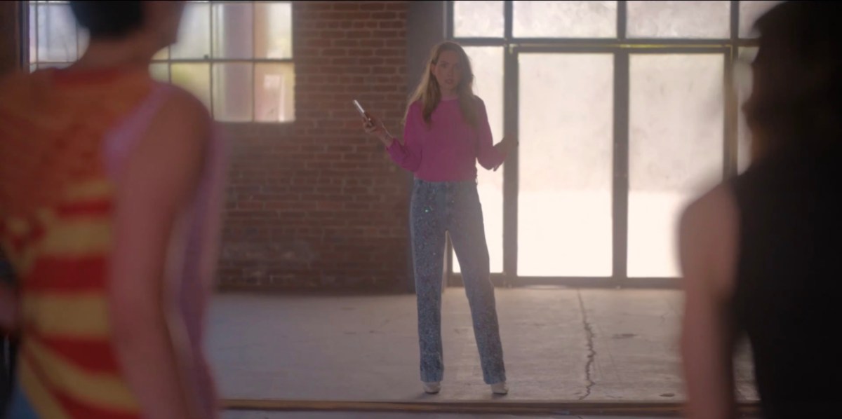 Tess standing in the empty room in her pink sweater sparklepants