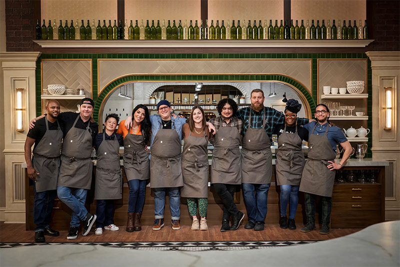 The contestants of The Big Brunch lined up in their aprons in the kitchen