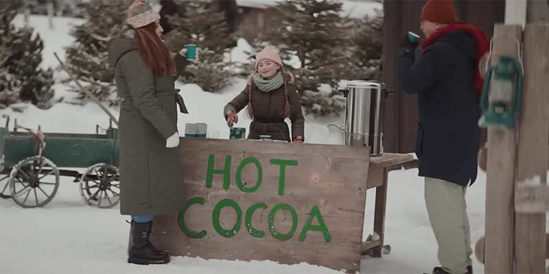A teenager girl selling hot cocoa in the snow