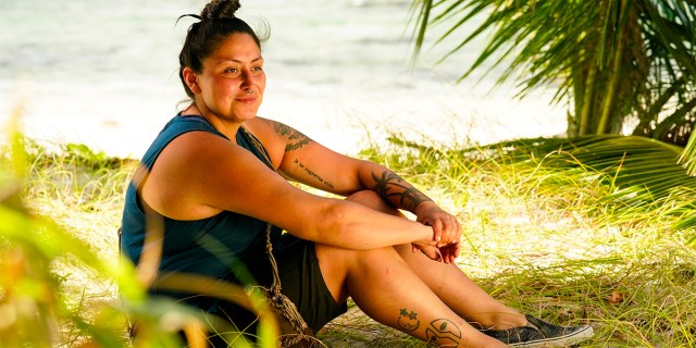 Karla sitting on the beach smiling