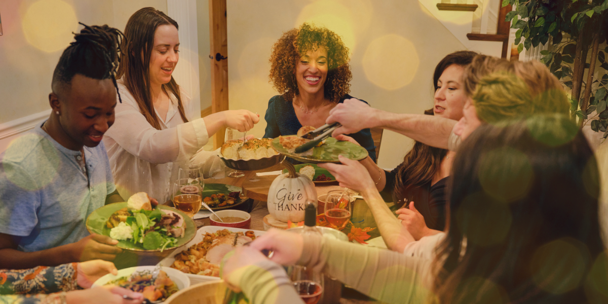 A group of friends dine around a table for Thanksgiving