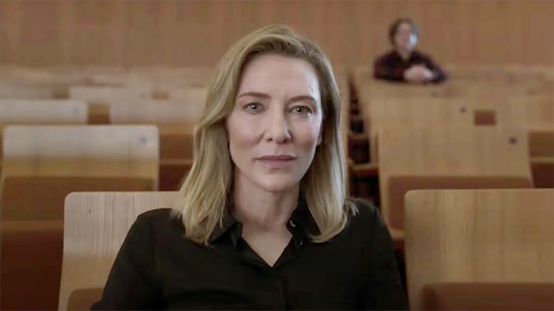 Cate Blanchett as Lydia Tar, sitting in classroom smiling