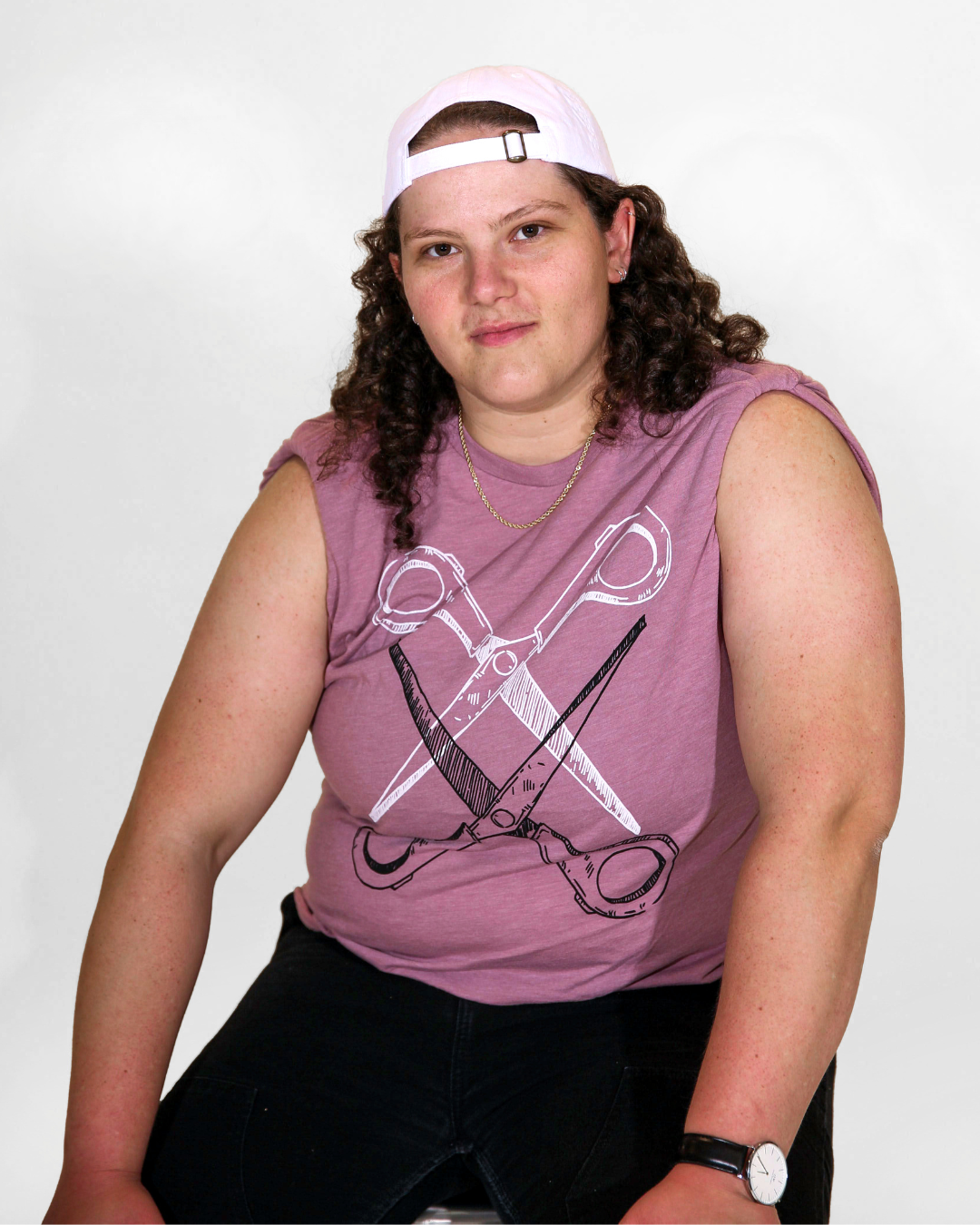 Model Jenny is wearing the Basic Scissoring Pink Tee in size S. They are 5'9" and their bra size is 38DDD. The tee is a dusty pink color with a graphic of two scissors in a vertical alignment. Their blades are open and overlapping each other. The top scissor is outlined in white and the bottom scissor in black.