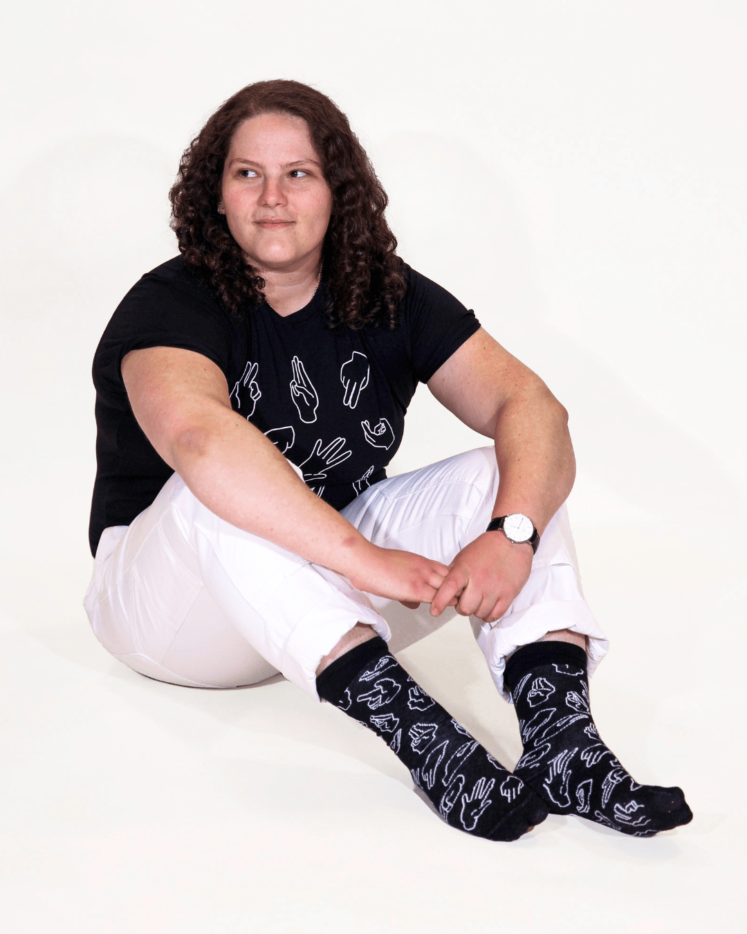 Model Jenny is wearing the Fisting 101 socks. The socks are black with line drawings of hand positions for sex in white color. The illustration was designed by Ren Strapp. The socks are Cotton crew style. The one size will fit a woman's size 6 up to a men's size 11.