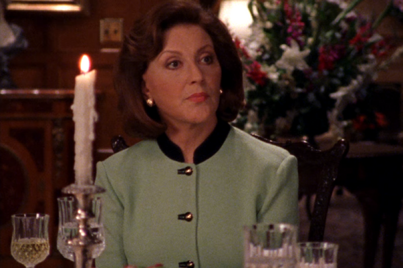Emily Gilmore on Gilmore Girls sitting at a candlelit dining table wearing a green jacket