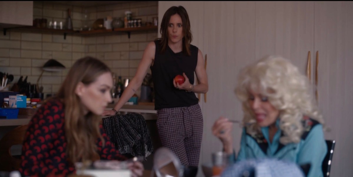 Shane holding an apple watching Tess and Patty at the table