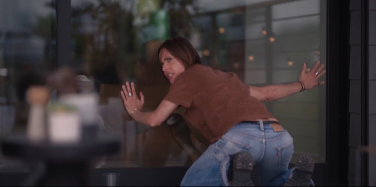 Shane with her hands against the glass and her butt out