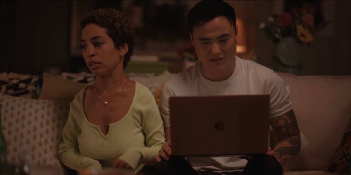 Micah looking at the sperm donor website upset and Maribel looking away also upset