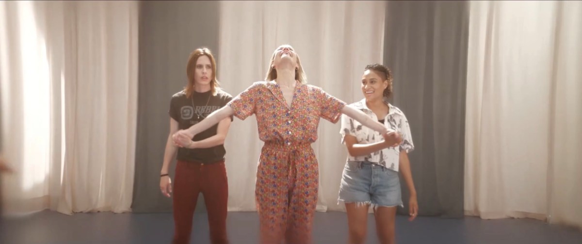 Alice stretching towards the sky with Shane and Sophie holding her wrists