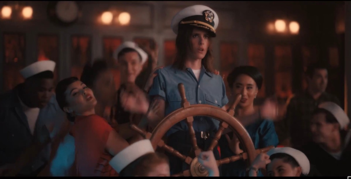 Shane at the captain's wheel in a crooked hat surrounded by damsels