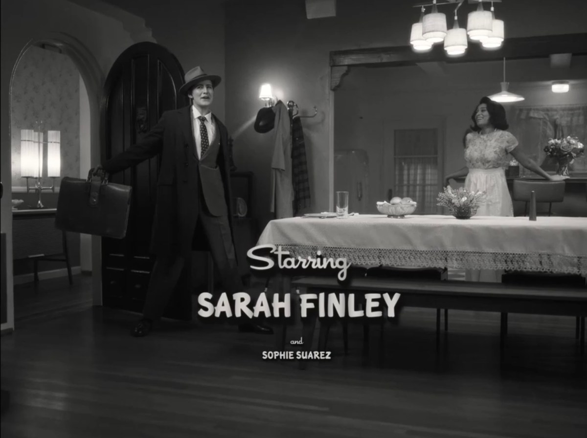 Finley in a suit and Sophie in a housedress in a black + white sitcom with the title card "Starring Sarah Finley" and then "and Sophie Suarez" in smaller font