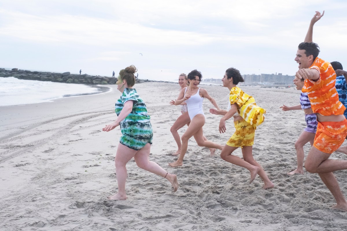 Everybody running on the beach in bright colored outfits