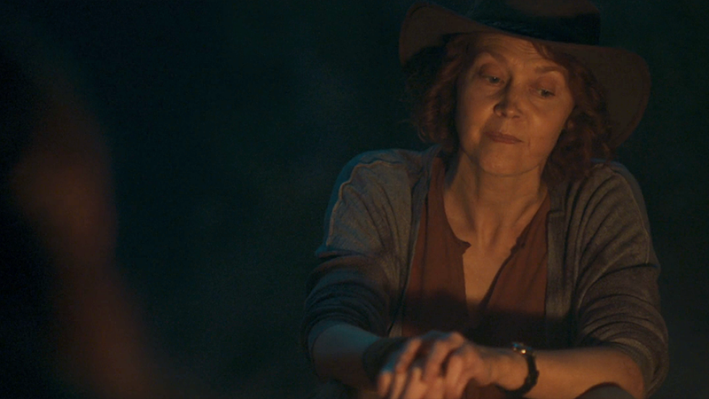 Mary pokes a campfire and tells her story. 