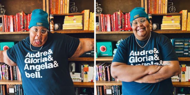 the writer shea wesley martin stands in front of bookshelves organized by color, wearing a t-shirt that reads "Audre & Gloria & Angela & bell" with a blue beanie.