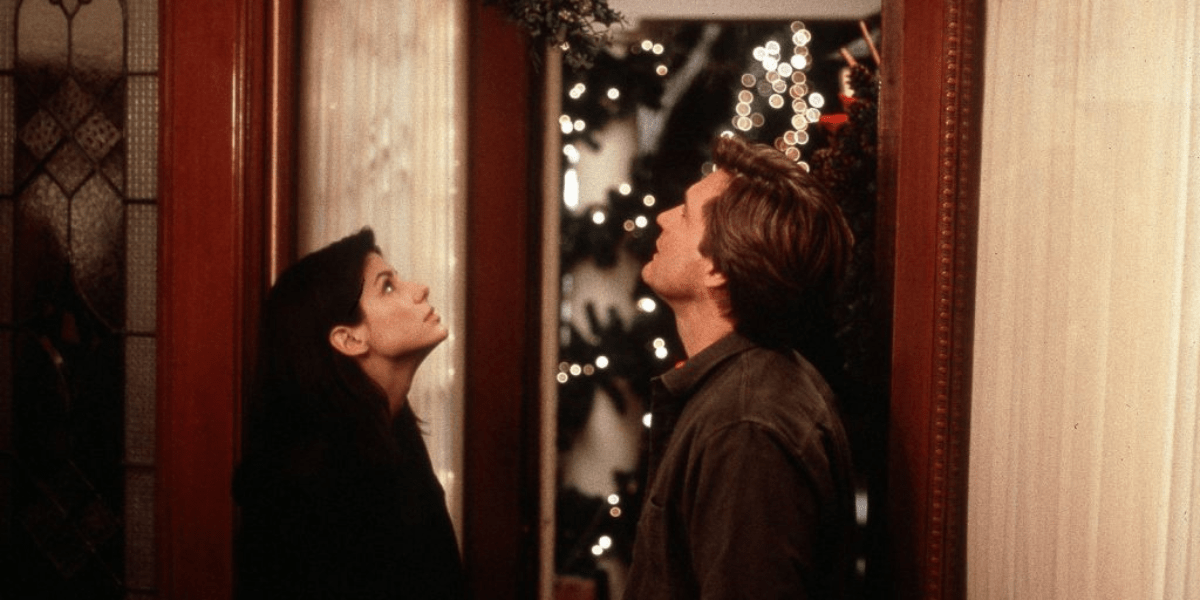 Sandra Bullock and Peter Gallagher under mistletoe in While You Were Sleeping
