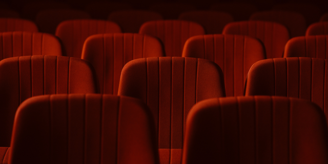 An empty movie theater with red chairs