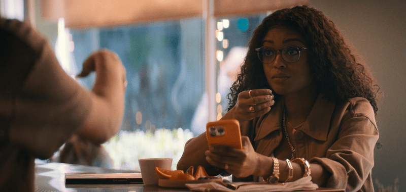 Sophia sitting at a counter and holding her phone.