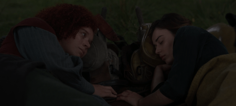 jade and kit lie next to each other with their fingers touching