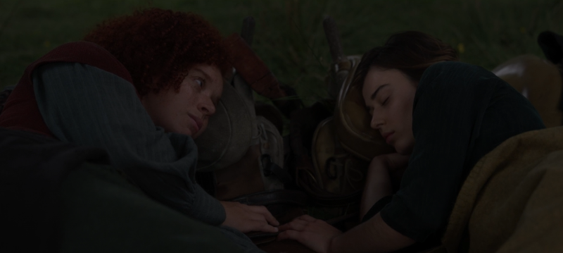 jade and kit lie next to each other with their fingers touching