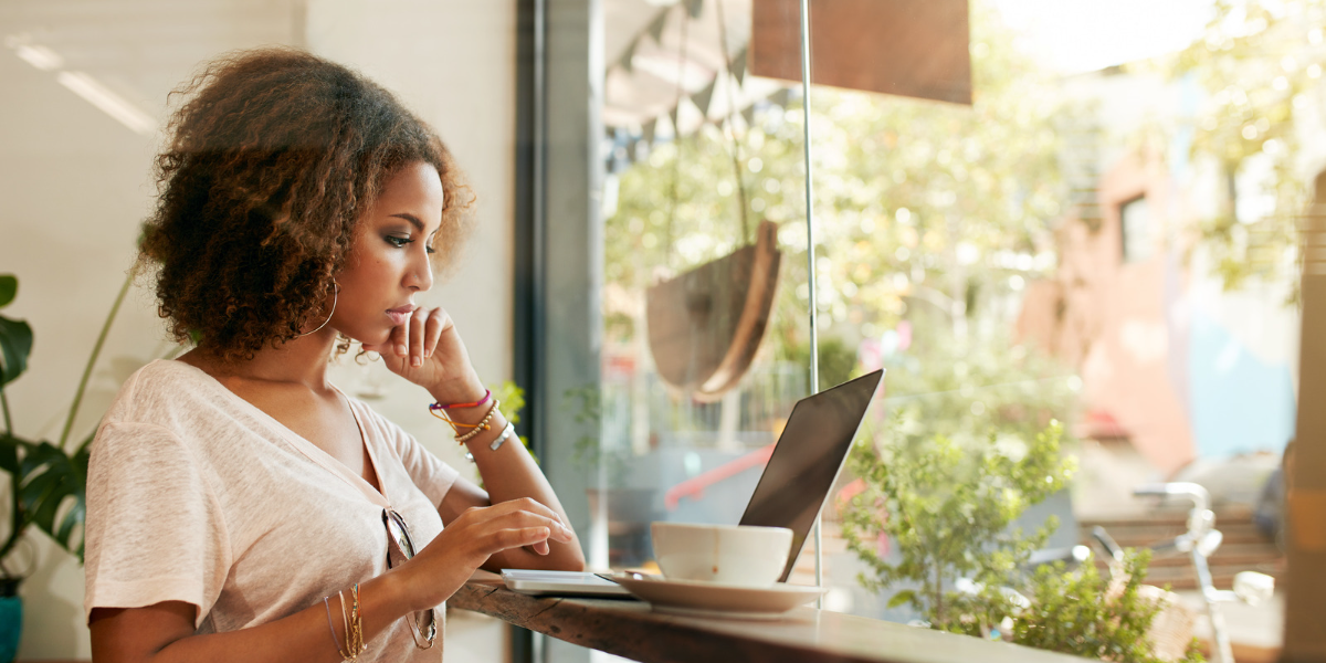 Black woman at a coffee shop on her computer