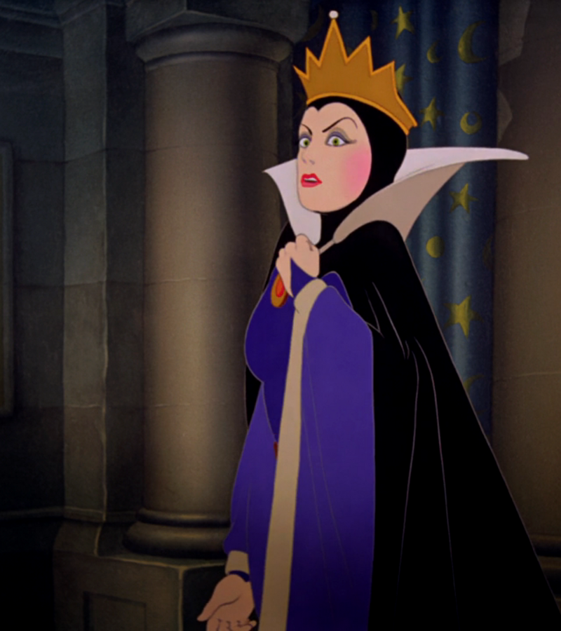 The evil queen from Snow White wears a crown and a black and purple cape dress. She has an angry look on her face.