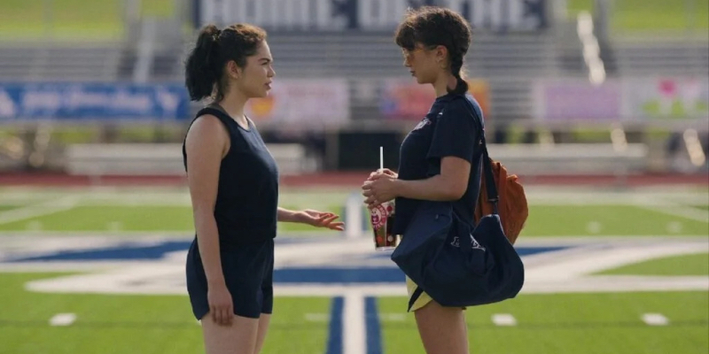 Two girls look at each other on a school track.