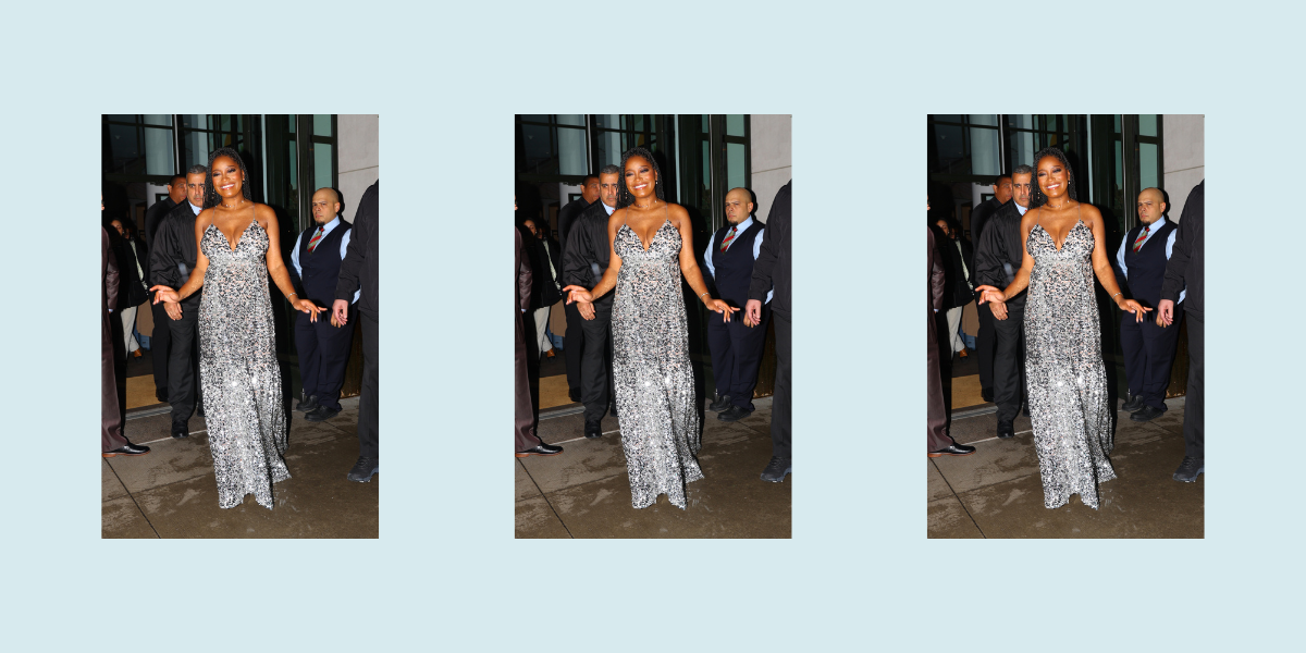 Keke Palmer wears a sparkly silver dress while walking into an event, beaming and pregnant